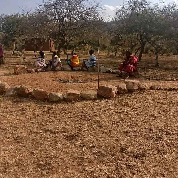 A circle of community elders gathered outdoors